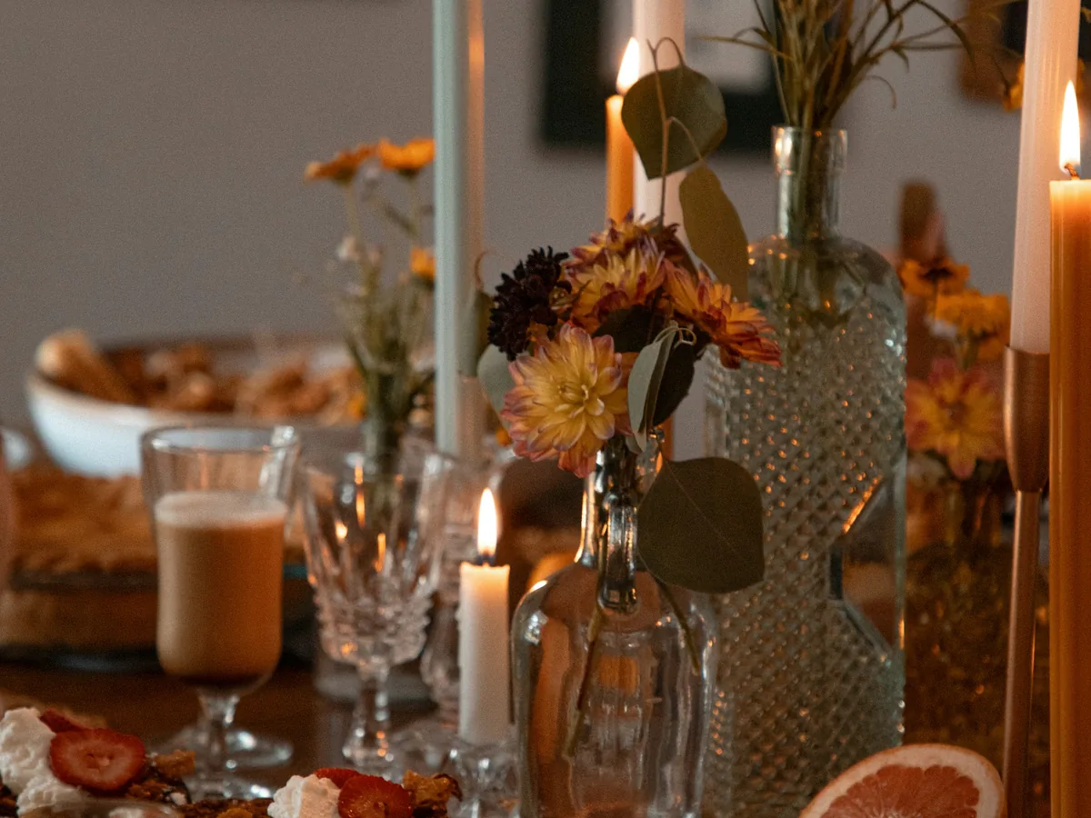 A table set with candles and plates of food for an evening meal