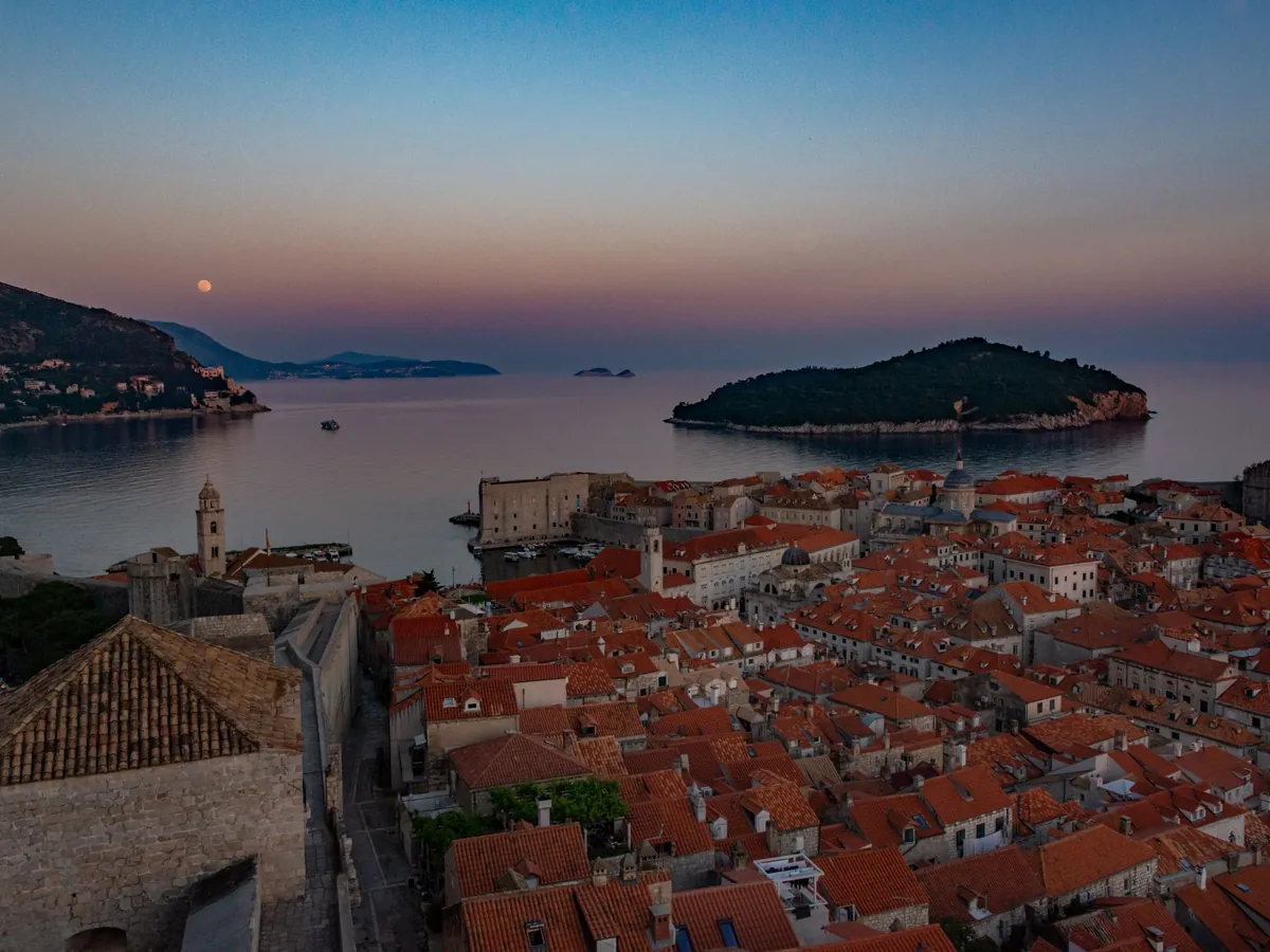 Dubrovnik's Old Town rooftops at dusk, with Lokrum island in the bay beyond
